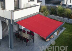 Weinor retractable patio awning extended over a dining area, aerial view