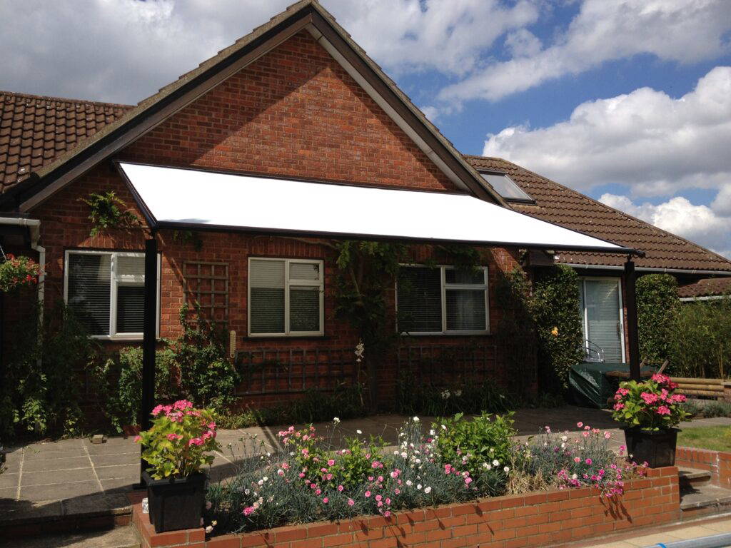 Weinor Plaza Viva pergola awning fitted above the entrance of a red brick bungalow
