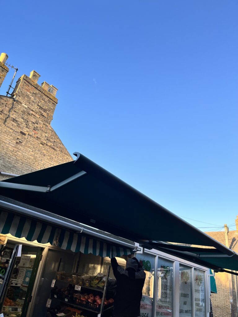 Weinor awning fitted above a greengrocer's shop front, street view