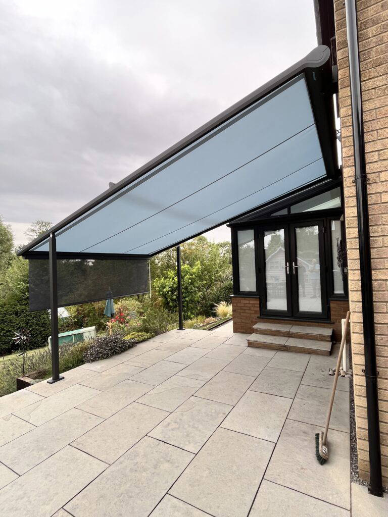 Weinor Plaza Viva pergola awning with integrated side zip screen above a conservatory
