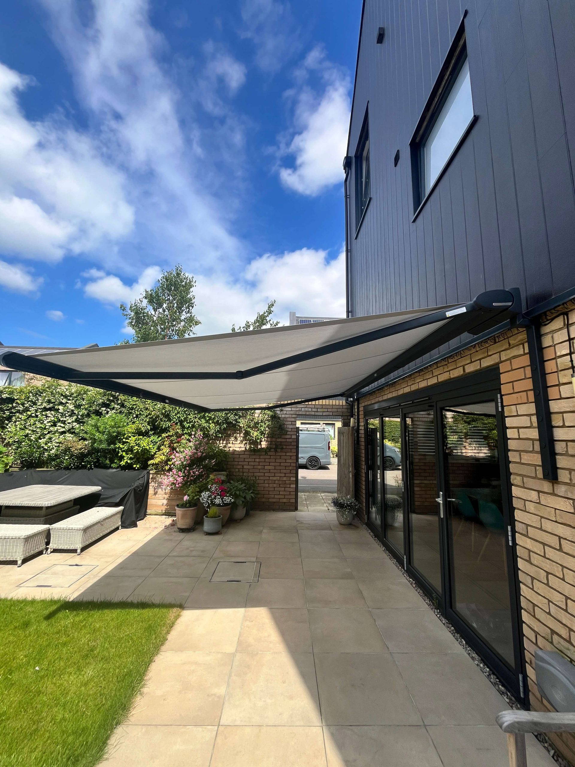 Weinor Cassita II awning fitted to a modern grey-clad house extension